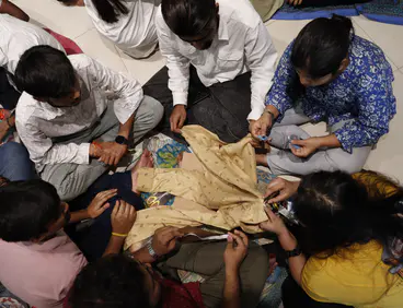 People sitting down inspecting a piece of sustainable clothing